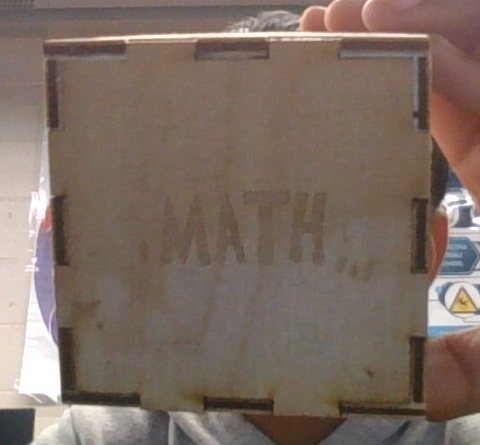 Cube face engraved with the word MATH